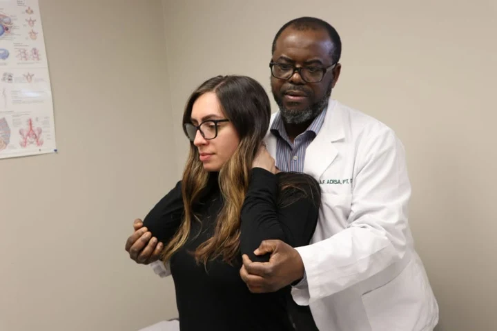 Dr. Abdul-Fatai Adisa treating a patient's neck and shoulder at RCA Physical Therapy