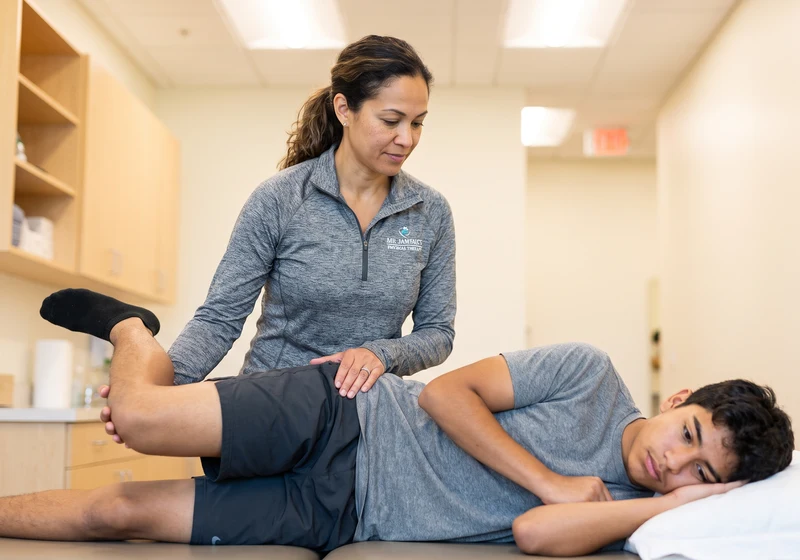 Physical therapist performing Active Release Technique on a patient's leg